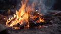 Bonfire burning down in the forest autumn, flame sticks and coals in fire close up on sand beach in the evening night