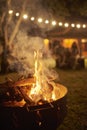 Bonfire burning in a garden a summer night, unknown people in the background Royalty Free Stock Photo