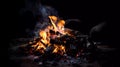 A bonfire with glowing coals. On a dark background
