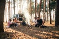 By bonfire. Group of friends are together in the forest