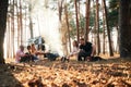 By bonfire. Group of friends are together in the forest