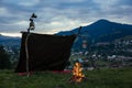 Bonfire near camping tents outdoors at evening in the mountains. Royalty Free Stock Photo