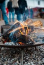 Bonfire spreading heat and cozyness at an outdoor market on a rainy day