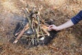 Bonfire in the spring forest on the background of withered grass. In the frame of the hand of a man. Royalty Free Stock Photo