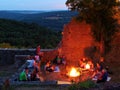 Campfire summer night in castle ruin by twilight