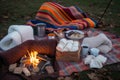 bonfire surrounded by blankets, hot chocolate, and marshmallows for s'mores