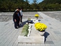 Four people pray by the mausoleum of Roh Moo-hyun, 16th president of South Korea. Bongha village