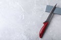 Boning knife, sharpening stone and space for text on grey background Royalty Free Stock Photo