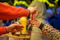 BONN, GERMANY - DECEMBER 6, 2022: A man hands a woman a bag of roasted almonds