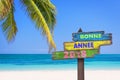 Bonne annee 2018 happy new year in french on a colored wooden direction signs, beach and palm tree background