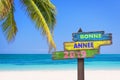 Bonne annee 2019 meaning happy new year in French on a colored wooden direction signs, beach and palm tree