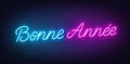 Bonne Annee neon lettering on brick wall background. Happy New Year greetings in French.