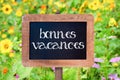 Bonnes vacances (meaning happy holiday) written on a vintage wooden frame chalkboard