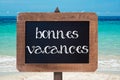 Bonnes vacances (meaning happy holiday) written on a wooden vintag chalk board Royalty Free Stock Photo