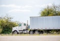 Bonnet big rig day cab semi truck with dry van semi trailer carry cargo for local delivery driving on the road