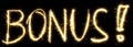 Bonus text. made of sparkler. Isolated on a black background. Royalty Free Stock Photo