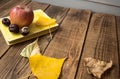 A book apple yellow leaves chestnut on wooden background