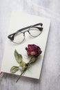 Book with beautiful dried rose and glasses Royalty Free Stock Photo