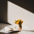 A book and a bunch of yellow dandelions. Still life with wild flowers. Play of light and shadow. Summer flowers Royalty Free Stock Photo