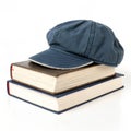Book with cap and another book on top isolated on white background Royalty Free Stock Photo