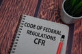 Book about Code Of Federal Regulations - CFR isolated on wooden table