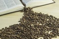 Book and coffee beans on a wooden table