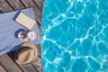 Book, coffee and sun hat near swimming pool Royalty Free Stock Photo