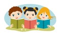 Book concept. Little cute group of three children reading a books sitting on the grass Royalty Free Stock Photo
