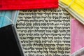 The Book of Esther is written in Hebrew on parchment next to colored surgical face masks
