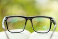 Book and eye glasses on wooden table with abstract green nature blur background. Reading and education concept Royalty Free Stock Photo