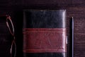 Book, eyeglasses and pen laid on old wooden table