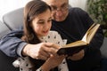 Book, family and children with a girl reading to her grandfather on the floor of their living at home. Kids, read and Royalty Free Stock Photo