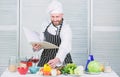 Book family recipes. Ultimate cooking guide for beginners. According to recipe. Man bearded chef cooking food. Guy read Royalty Free Stock Photo