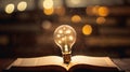 book of fiction on top bokeh light bulb