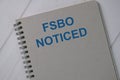 Book about FSBO Noticed isolated on wooden table