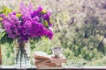 Book, glasses, cup of tea and lilac on a wooden window. Fragrant tea in the garden. Romantic concept Royalty Free Stock Photo