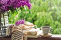 Book, glasses, cup of tea and lilac on a wooden window. Fragrant tea in the garden. Romantic concept Royalty Free Stock Photo