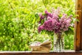 Book, glasses, cup of tea and lilac on a wooden window. Fragrant tea in the garden. Romantic concept Royalty Free Stock Photo