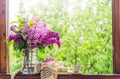 Book, glasses, cup of tea and lilac on a wooden window. Fragrant tea in the garden. Romantic concept Royalty Free Stock Photo