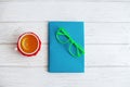 Book, glasses and a cup of tea on a white background. Top view. Royalty Free Stock Photo