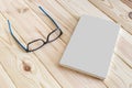 Book and glasses mockup on wooden background. Royalty Free Stock Photo