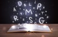 Book with glowing letters flying out on wood deck