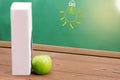 Book and Green apple on chalkboard background. Royalty Free Stock Photo