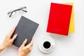 Book in hands for reading and education with coffee and glasses on white background flatlay