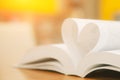 Close up page of book in heart shape at library of love to read and reading text book and February