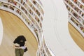 A book lover walks through bookshelves in the library in Singapore.