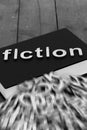 Book novel with the word fiction and blurred letters coming out of the pages