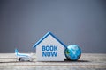 Book now. House booking. Tickets reservation. Worldwide travel. Holiday and relax concept. Miniature building and globe.