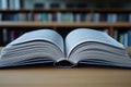A book is open on a table with a library background Royalty Free Stock Photo