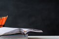 book and pencil on white table black board background Royalty Free Stock Photo